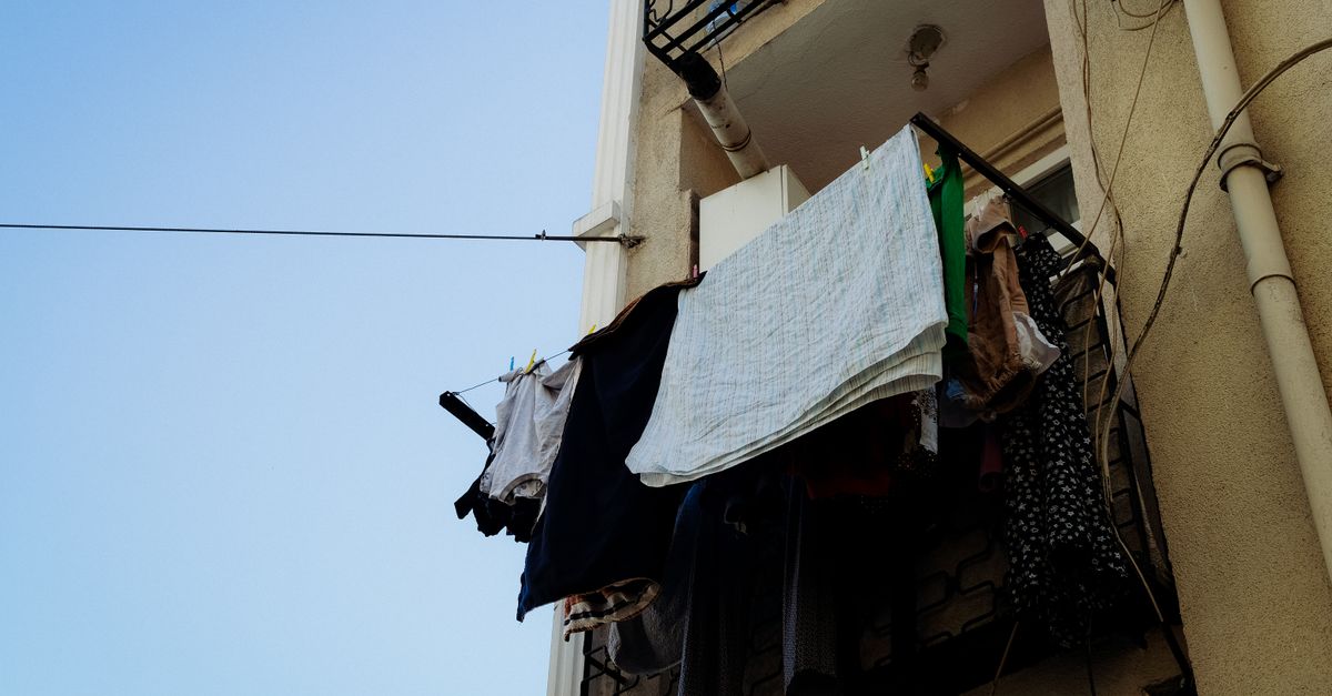 Bucato steso ad asciugare su una corda tesa vicino al balcone di un condominio