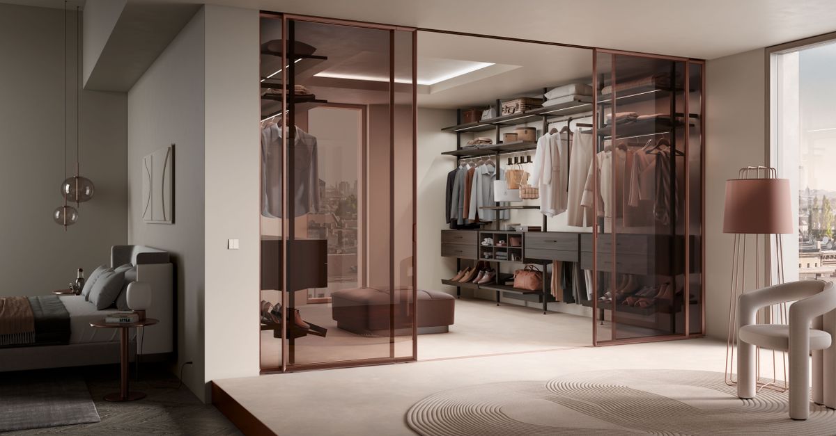 Cabina armadio con ante scorrenti in vetro e organizzatori interni con vestiti appesi, scarpiera e cassetti visibili accanto alla camera da letto.